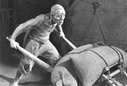 Photo of sculpture of old man with wheelbarrow